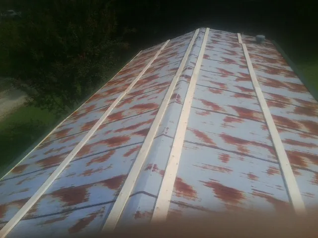 Rusted metal roof panels with new wood purlins before replacement — Storm Damage Roof Repair in Seneca Falls by Roofing Brothers